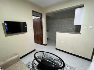 a room with a tv and a table in a room at Oltotoi Suites in Nairobi