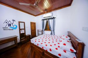 una camera da letto con un letto con cuori rossi sopra di Inpan's beach resort Batticaloa a Batticaloa Altre 229 foto