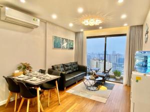 un salon avec un canapé et une table dans l'établissement QMP - Vinhomes D'Capitale Tran Duy Hung, à Hanoï