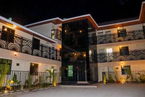 a large white building with a balcony at night at Oltotoi Suites in Nairobi