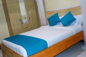 a bed with blue pillows in a room at Oltotoi Suites in Nairobi +6 photos