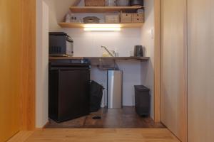 a small kitchen with a sink and a refrigerator at 旅宿ときじくTokijiku in Nachikatsuura