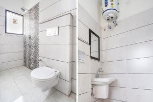 a white bathroom with a toilet and a sink at FabHotel Red Ark Inn in Lāndrān