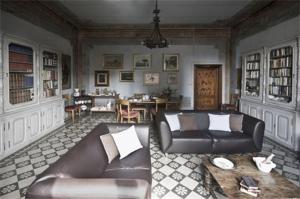 a living room with a leather couch and a table at B&B Canto Alla Porta Vecchia in Pistoia