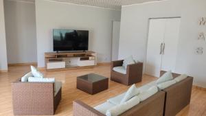 a living room with two couches and a flat screen tv at Villa MAS - Condominio Hacienda II in Pachacamac