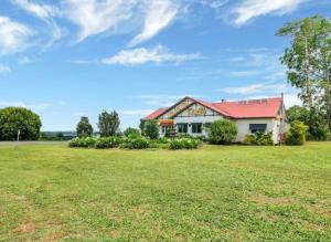 a house with a green field in front of it at The Falls Teahouse in Millaa Millaa
