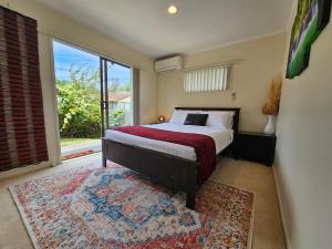 a bedroom with a bed and a large window at Bright & Cozy Studio - Private Access & Full Privacy in Auckland