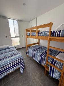 a bedroom with two bunk beds and a window at Linda Casa en Condominio in Asia
