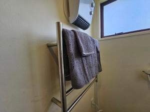 a bathroom with a towel rack and a mirror at Bright & Cozy Studio - Private Access & Full Privacy in Auckland