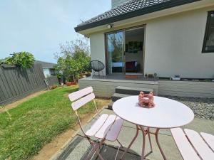 a table and chairs in front of a house at Bright & Cozy Studio - Private Access & Full Privacy in Auckland