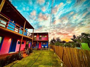 una casa con una valla delante de una puesta de sol en Cara,Viva Flats, en Porto Seguro
