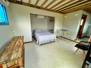 Un dormitorio con una cama y una mesa dentro. en Cara,Viva Flats, en Porto Seguro
