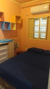 サン・ガブリエウにあるHouse Medeirosのベッドと机と窓のある寝室