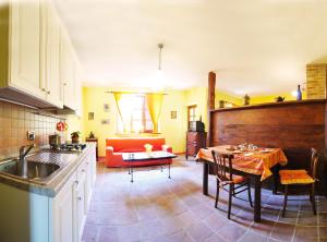 a kitchen with a table and a living room at Da Ivana e Valter in Monforte dʼAlba