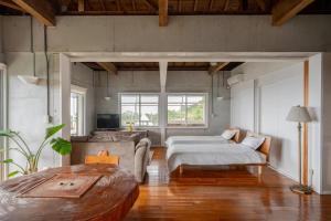 a large bedroom with two beds and a couch at PANORAMA Ocean View Cottage in Motobu