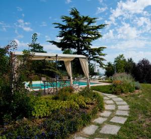 a garden with a pool and a pavilion at TENUTA MONTEGRANDE 1893 in San Salvatore Monferrato