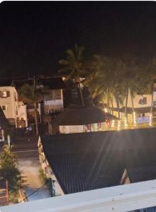a view of a pool at night with palm trees at Les mirabelles in Grand Baie