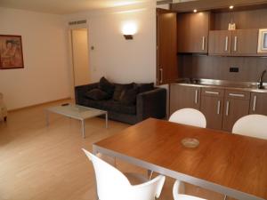 sala de estar con sofá, mesa y sillas en Apartaments Sant Jordi Fontanella, en Barcelona