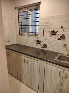 a kitchen with a sink and a window at KOTLAS Highliving Service Apartments in Gachibowli