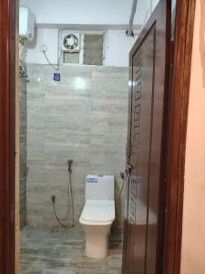 a bathroom with a toilet and a shower at KOTLAS Highliving Service Apartments in Gachibowli