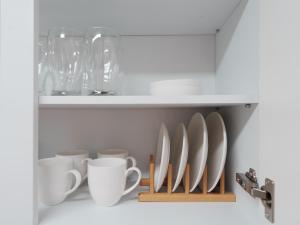 a shelf with cups and utensils in a cabinet at Yuri Stay 2 jamsil coex lotteworld 아산병원 삼성병원 in Seoul