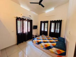 a bedroom with a bed and a ceiling fan at Aagneyam mansion in Kozhikode
