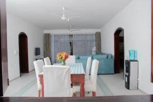 comedor con mesa y sofá azul en Marially luxury 2, en Malindi