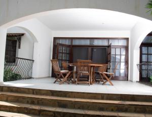 patio con mesa, sillas y TV en Marially luxury 2, en Malindi