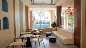 a restaurant with tables and chairs and a couch at Khách sạn lê lợi in Quang Ngai