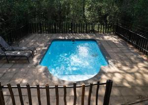 a swimming pool on a patio with a chair at Mazuri Bush Cottages in Hluhluwe