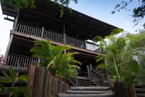 a building with stairs leading up to it with palm trees at Mazuri Bush Cottages in Hluhluwe