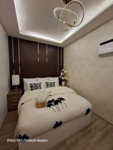 a bedroom with a large white bed with a chandelier at Carpe Diem Staycation in Mactan Island