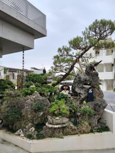 a statue of a pine tree on a rock at Room Biotop YOMITAN in Yomitan