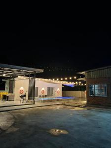a gas station at night with a bench in a parking lot at The Rina Homestay-Whole Villa with Private Pool,BBQ & Karaoke-1Min Beach- in Port Dickson