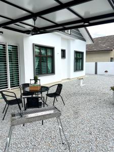 a patio with chairs and a table in front of a house at Jan2025 New Reno De Blackwood Home in Port Dickson
