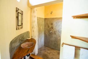 a bathroom with a wooden sink and a shower at Tree House Cottage, Garden Views, Hot Water in Praia do Tofo +10 photos
