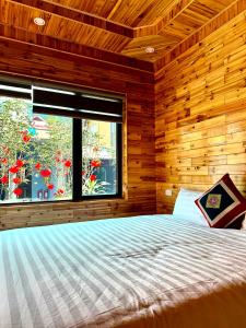 a bedroom with a large bed with a window at Viena Homestay in Bắc Hà