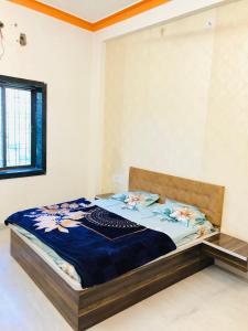 a bedroom with a bed with a blue blanket at Madhav Hotel & Restaurant in Bedla