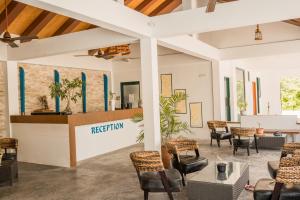 vestíbulo con sillas y recepción en Long Beach Laamu Hotel, en Gan