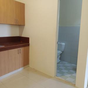 a bathroom with a toilet and a glass shower door at Mactan Rooms affordable in Lapu Lapu City