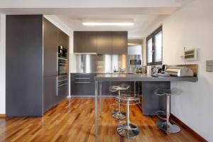 cocina con electrodomésticos de acero inoxidable y suelo de madera en Topfloor Luxembourg Ville, en Luxemburgo