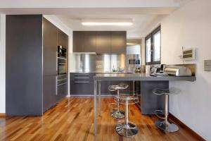 a kitchen with stainless steel appliances and wood floors at Topfloor Luxembourg Ville in Luxembourg