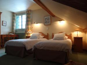 A bed or beds in a room at Auberge Des Chasseurs