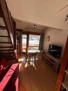 un salon avec une table et une télévision dans l'établissement Appartement Morzine, deux pièces, mezzanine, 4 personnes, à Morzine