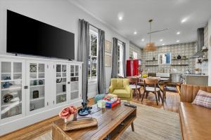 a living room with a tv on a wall at Pleasure Pier Modern Home Nr Beach Bbq Games in Galveston