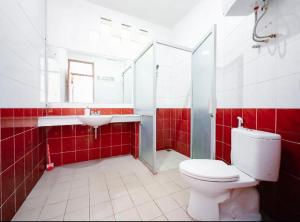 une salle de bain rouge et blanche avec des toilettes et un lavabo dans l'établissement Villa Istana Bunga - The Green Villa 4 Bedroom, à Bandung