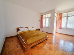 une chambre avec un grand lit avec un plancher en bois dans l'établissement Villa Istana Bunga - The Green Villa 4 Bedroom, à Bandung