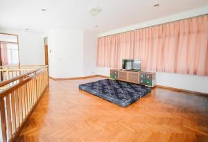 un salon avec une télévision et un canapé dans l'établissement Villa Istana Bunga - The Green Villa 4 Bedroom, à Bandung