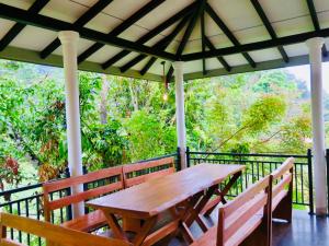 a wooden table and benches on a porch at Wildlife Kingdom - Deniyaya Sinharaja in Deniyaya