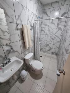 a white bathroom with a toilet and a sink at Villas La Vista in Tuxpan de Rodríguez Cano +14 photos